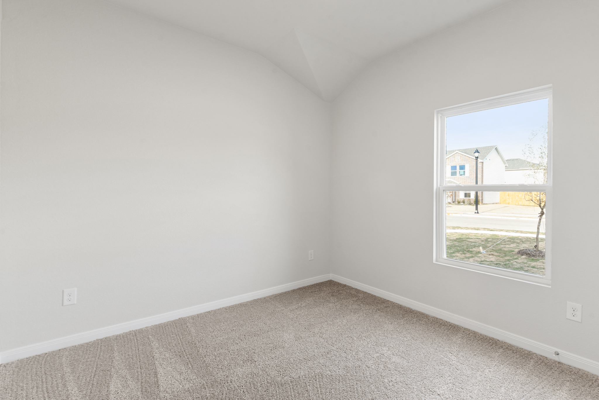 A room with a window and a door with a view of a street.