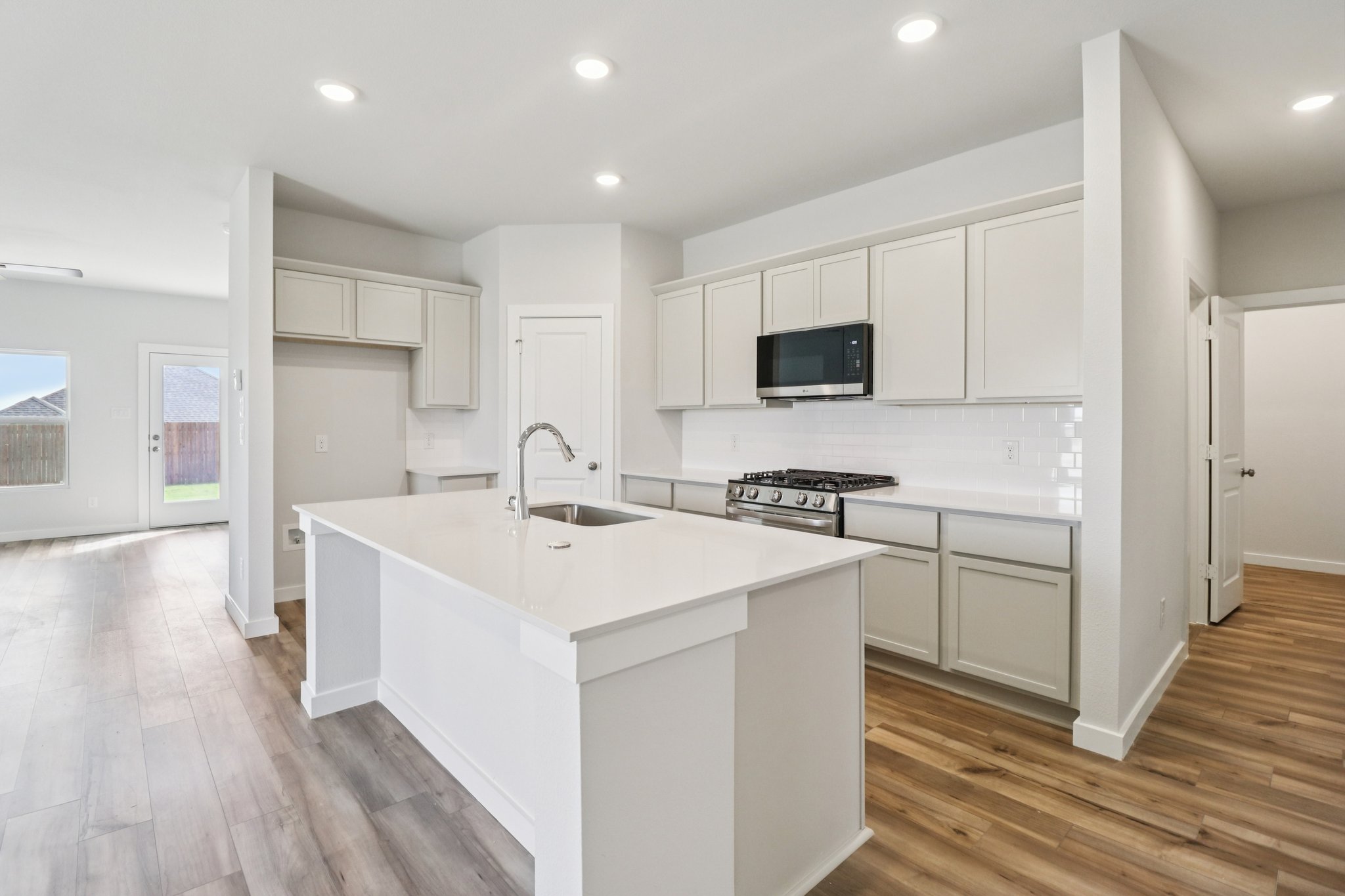 A kitchen with white cabinets.
