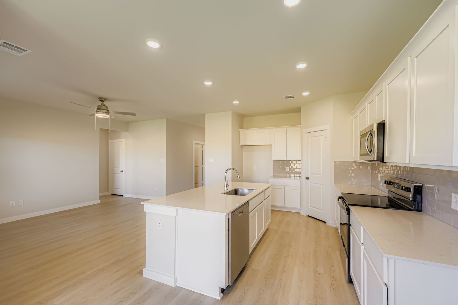 A kitchen with white cabinets.