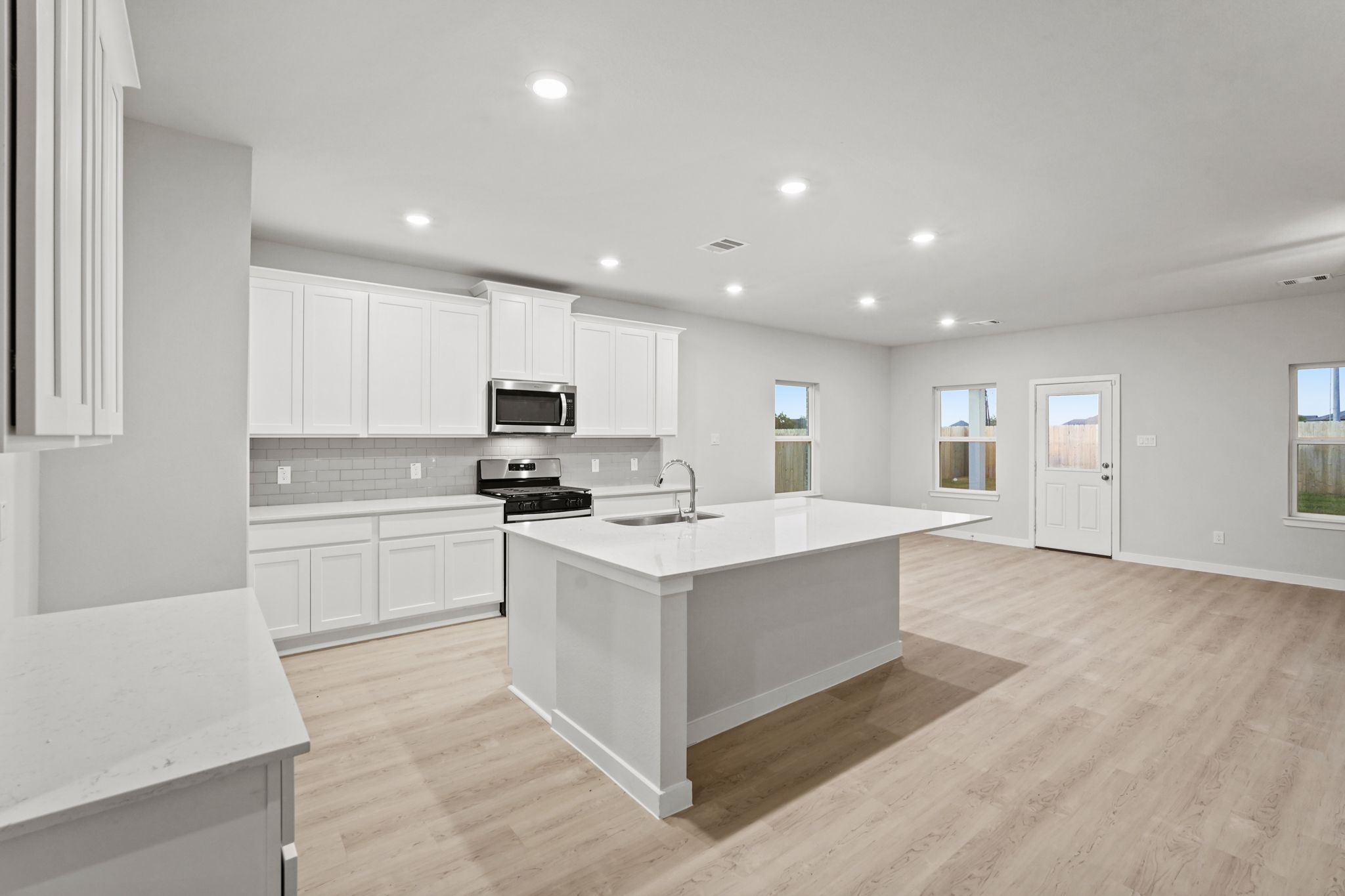 A kitchen with white cabinets.
