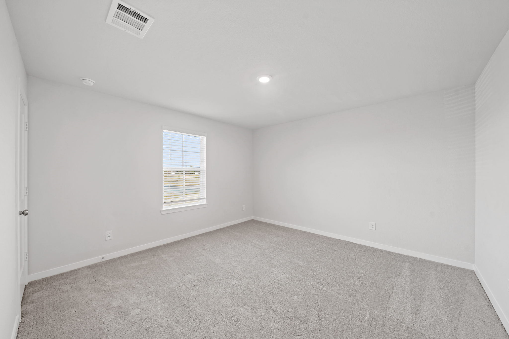 A room with a carpet and a window.