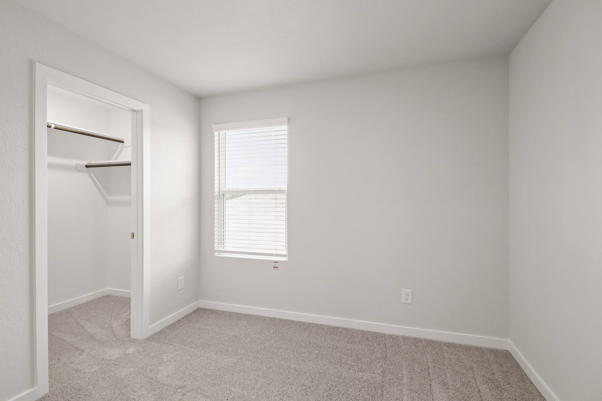 A room with a window and a shelf.