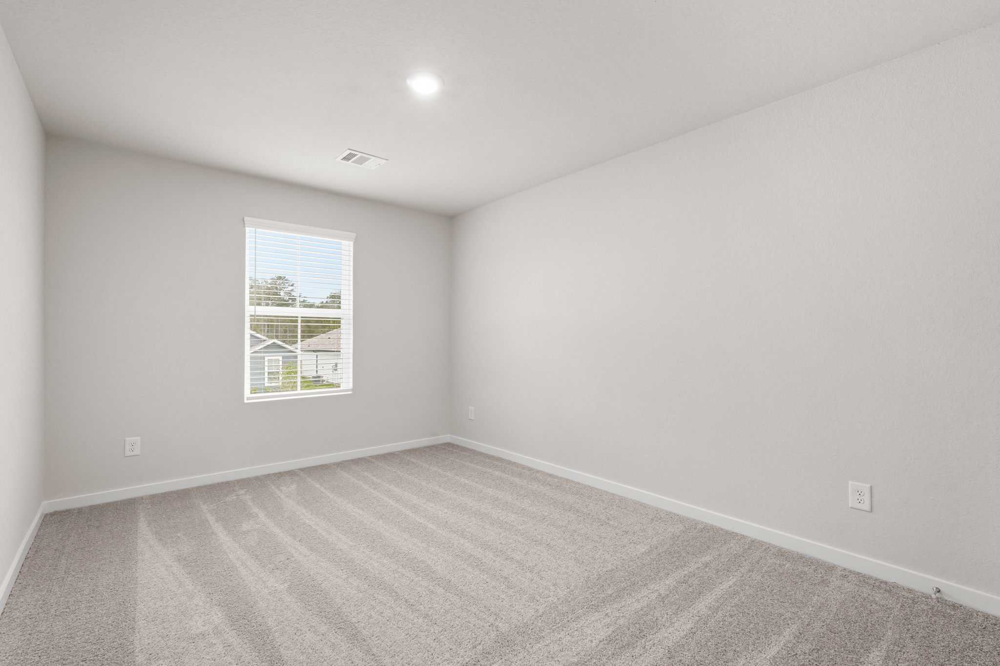 A room with a window and a carpet.