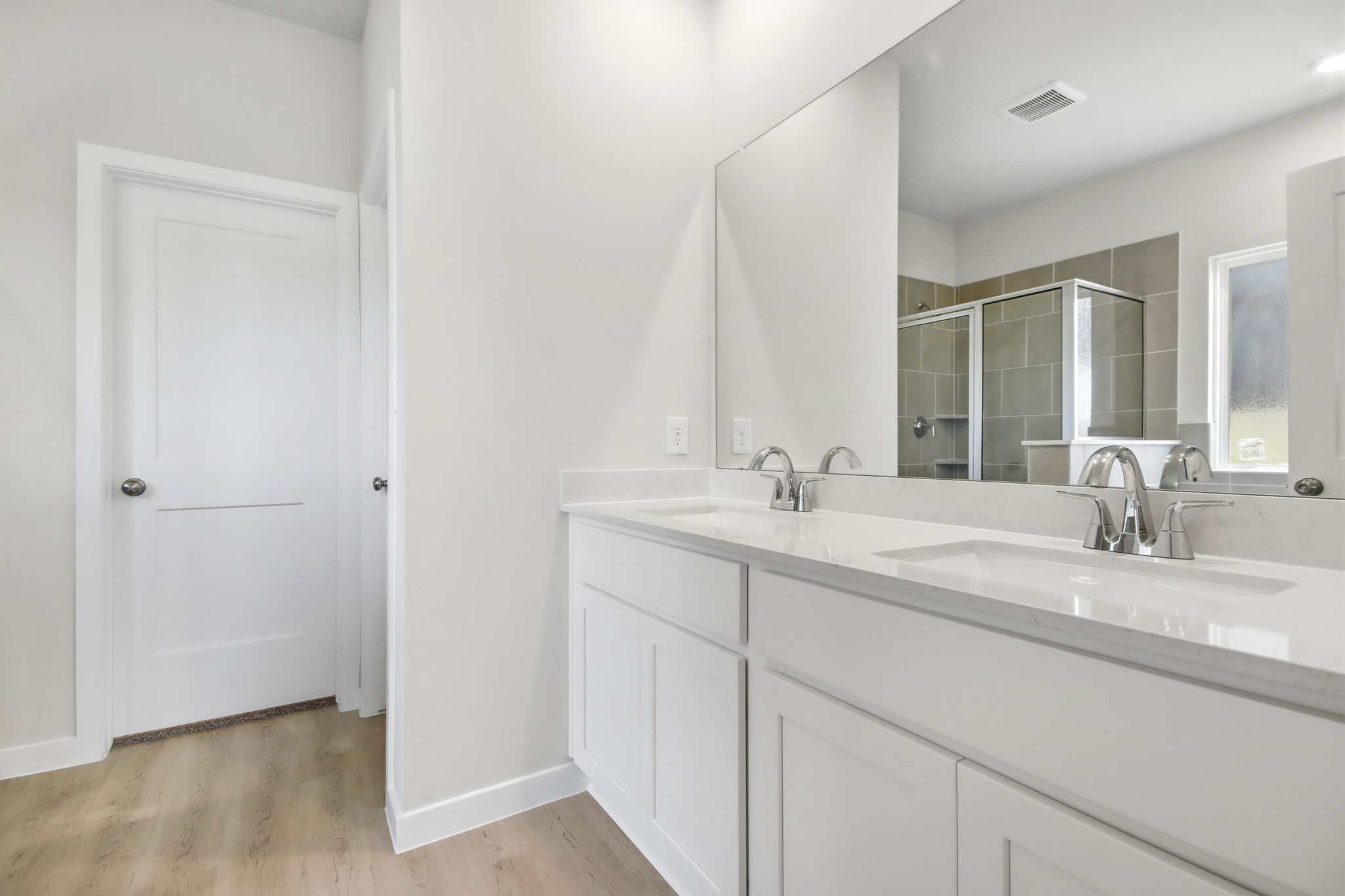A bathroom with white cabinets.