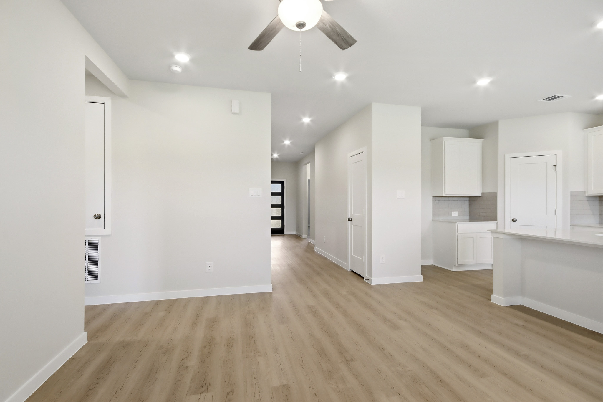 A large empty room with white cabinets.