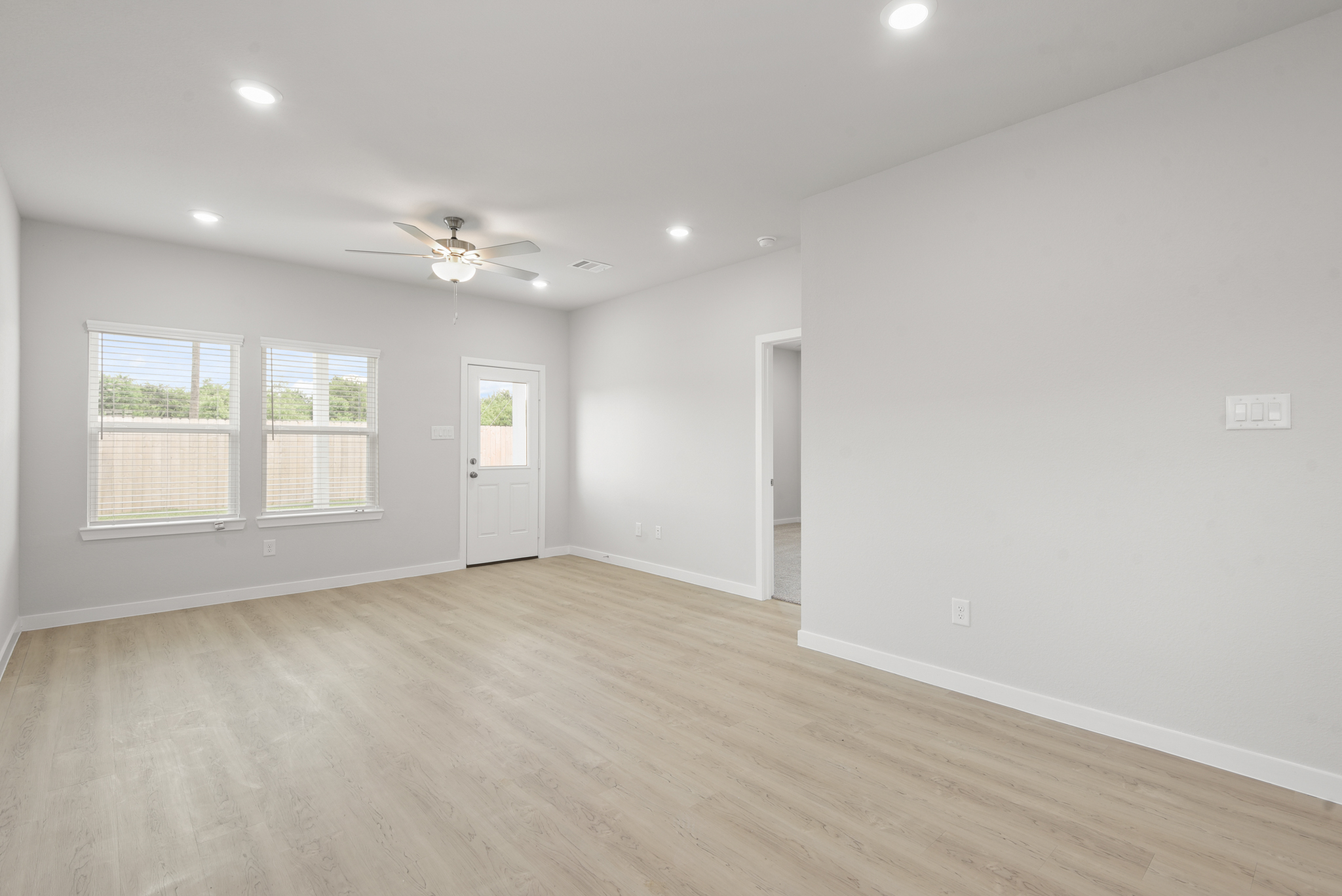 A room with a wood floor and a ceiling fan.