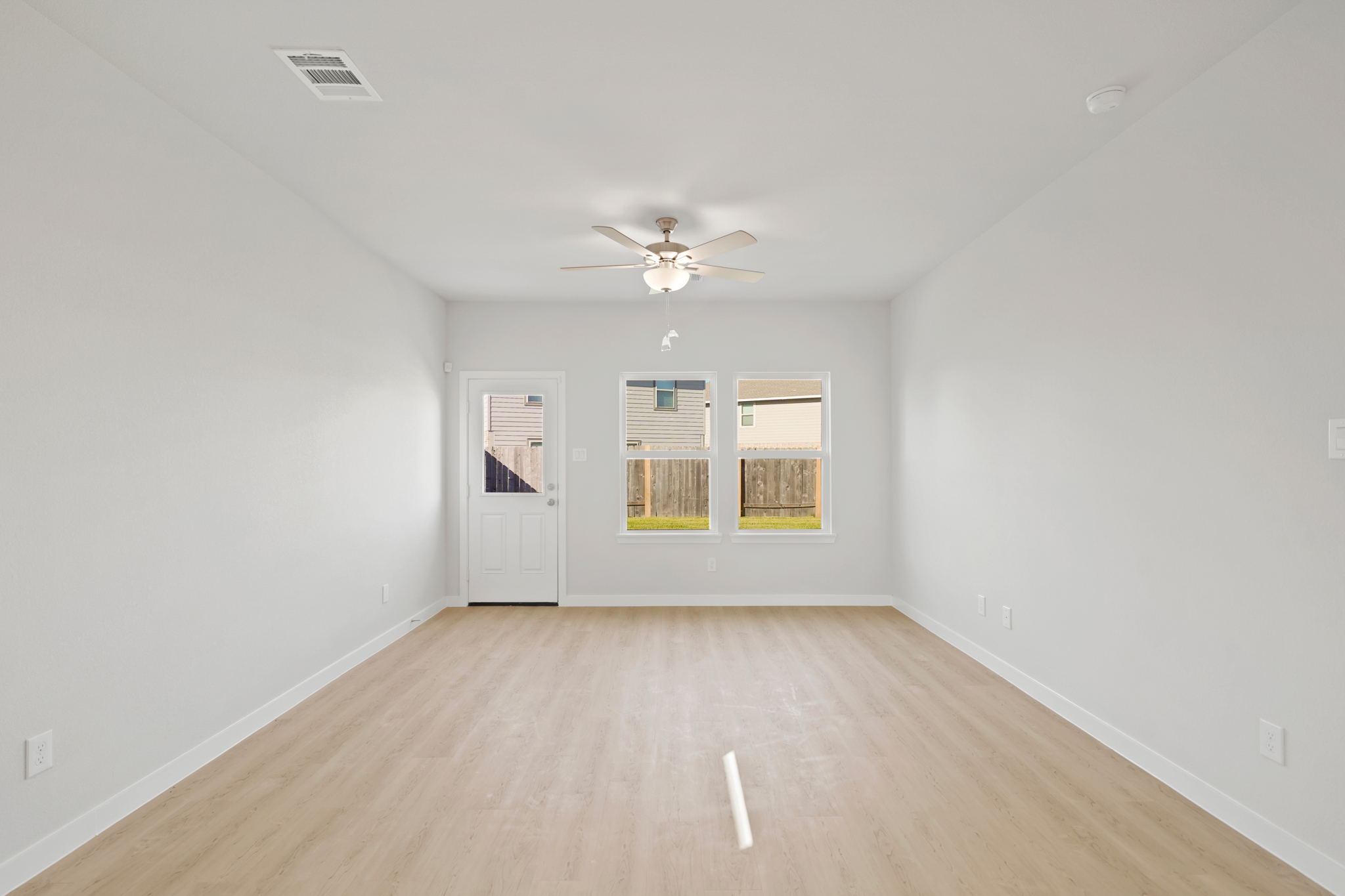 A room with a wood floor and a ceiling fan.