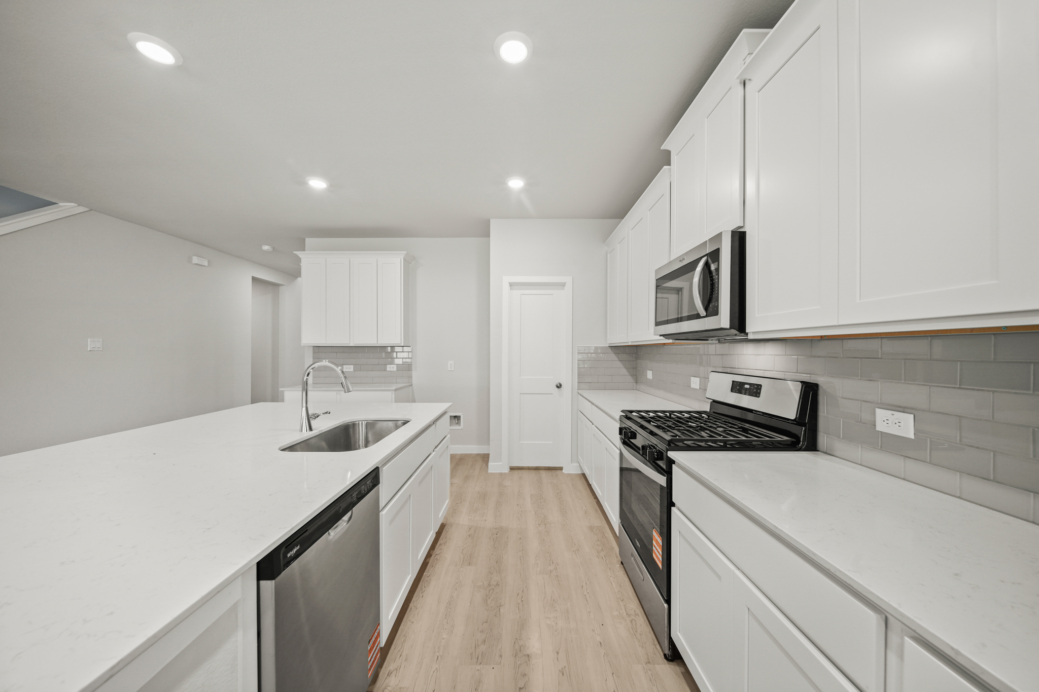 A kitchen with white cabinets.