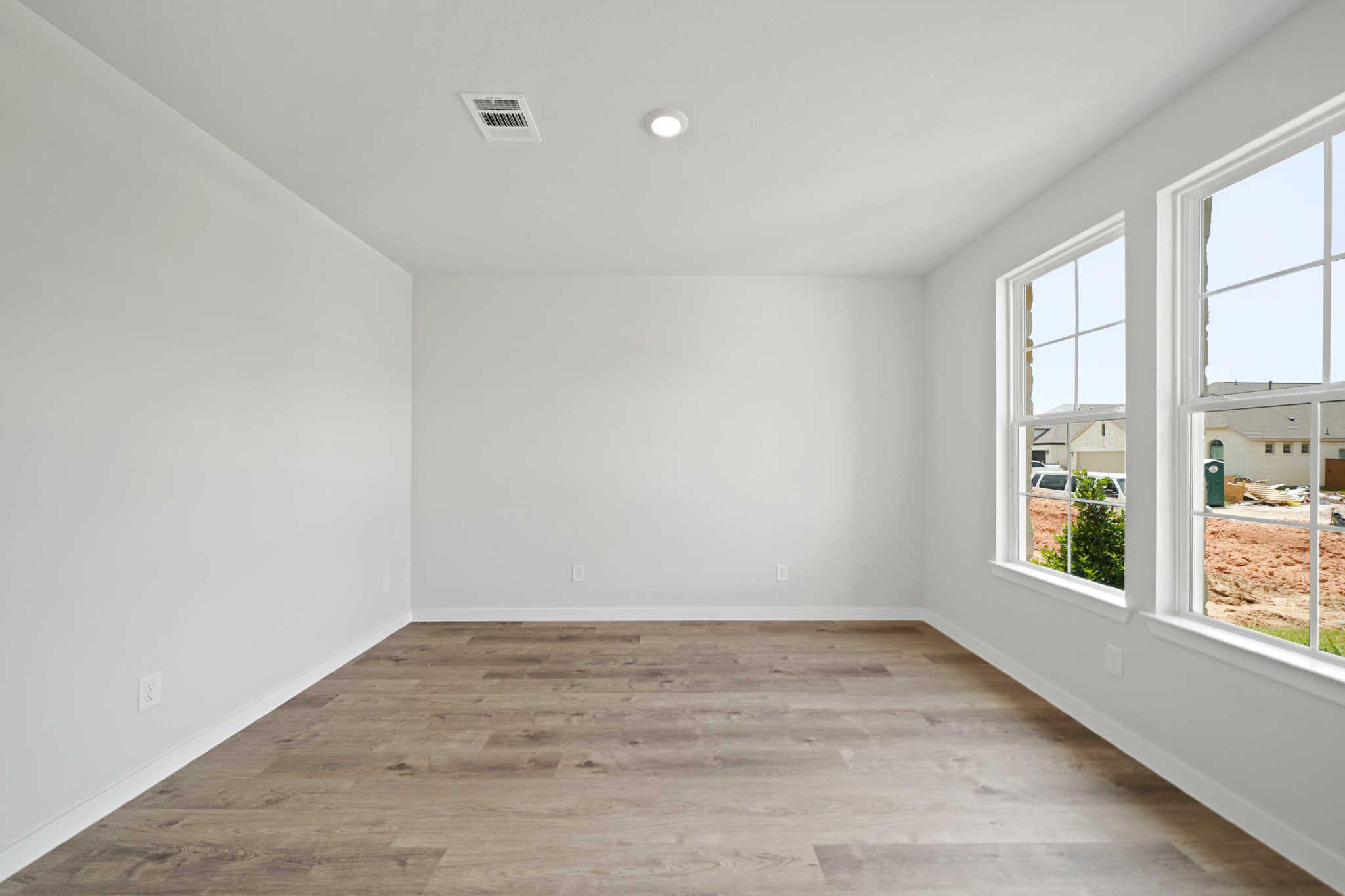 A room with windows and a wood floor.