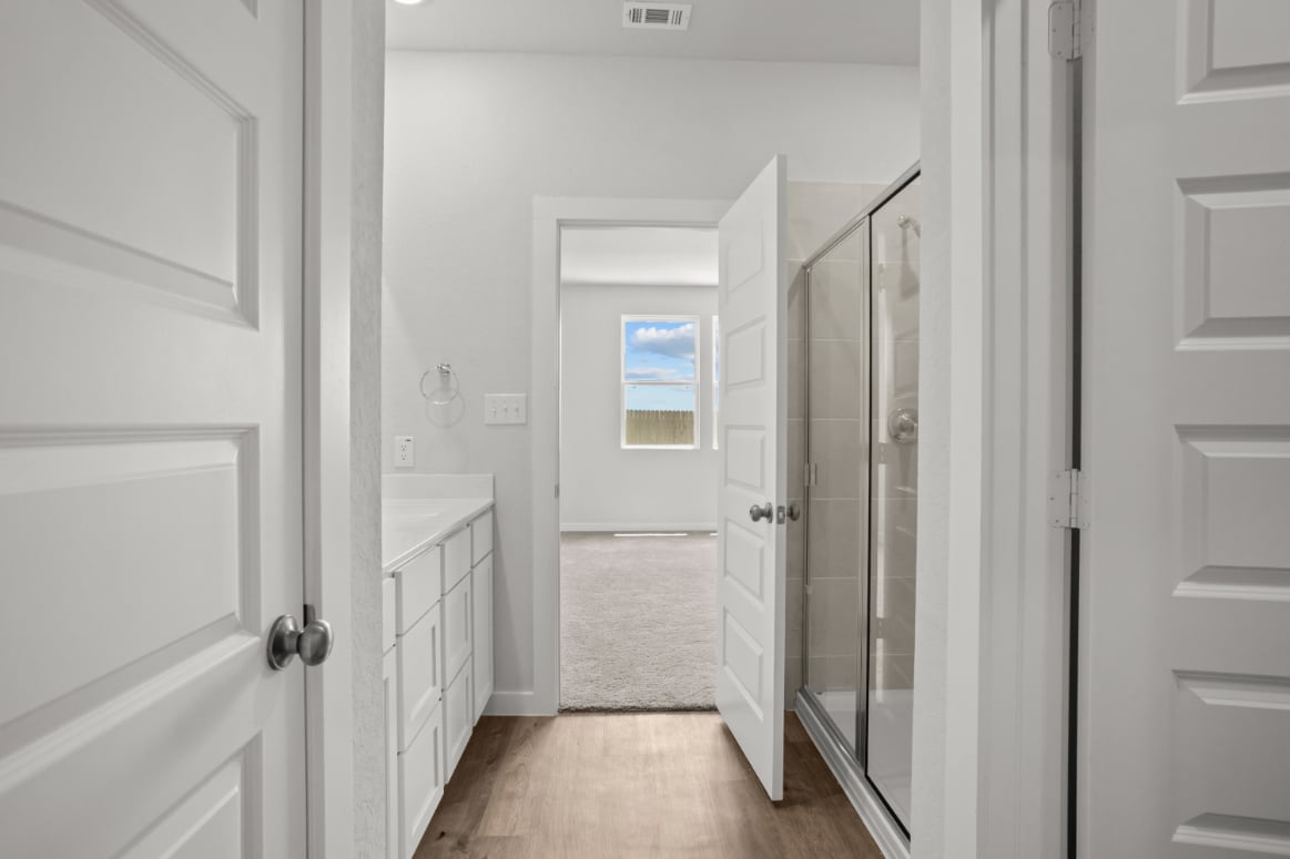 A bathroom with white cabinets.