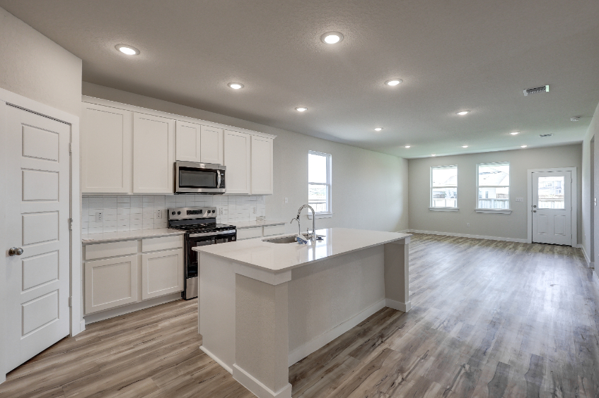 A kitchen with white cabinets.