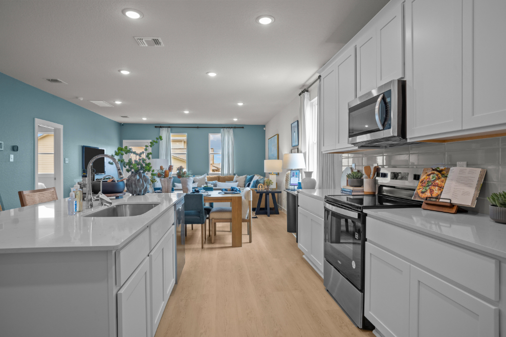 A kitchen with white cabinets.