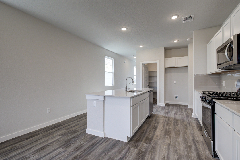 A kitchen with white cabinets.