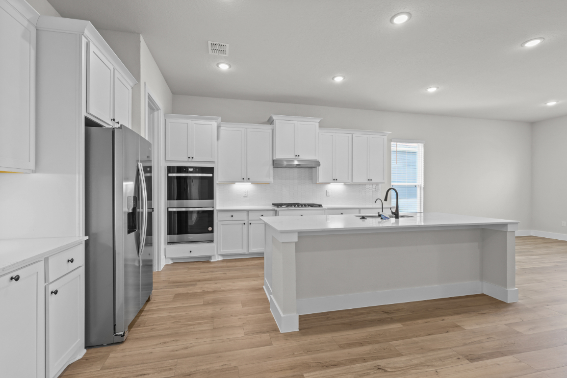 A kitchen with white cabinets.