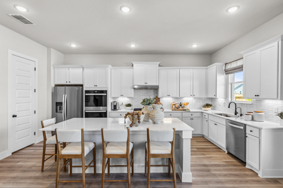 A kitchen with white cabinets.