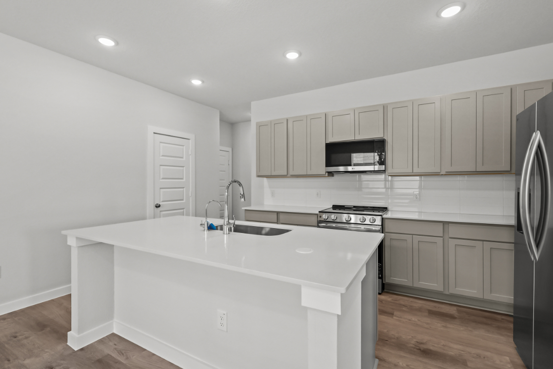 A kitchen with white cabinets.