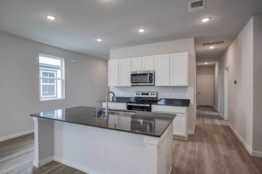 A kitchen with white cabinets.