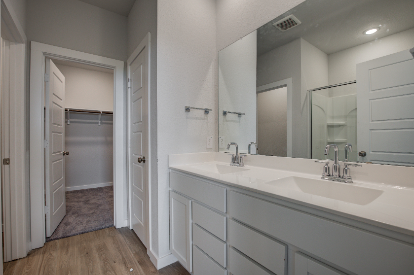 A bathroom with white cabinets.