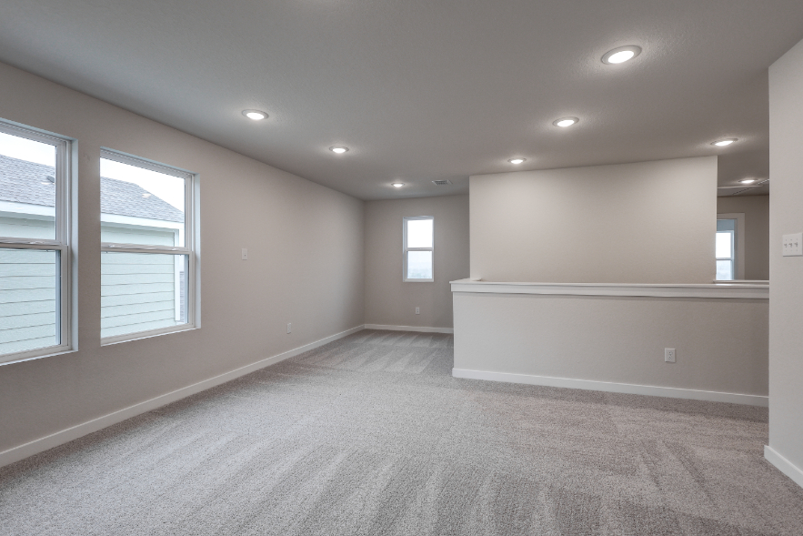 A room with a white wall and windows.