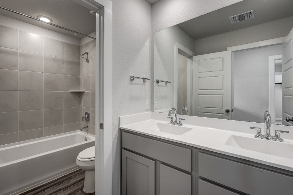 A bathroom with a tub sink and toilet.
