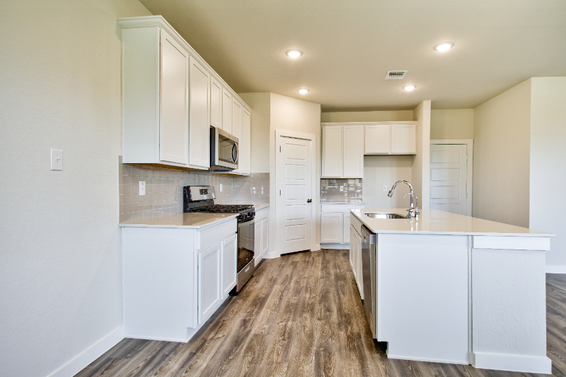 A kitchen with white cabinets.