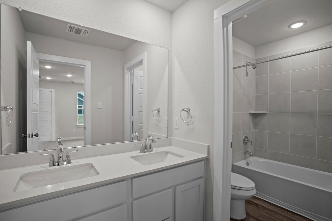 A bathroom with a tub sink and toilet.
