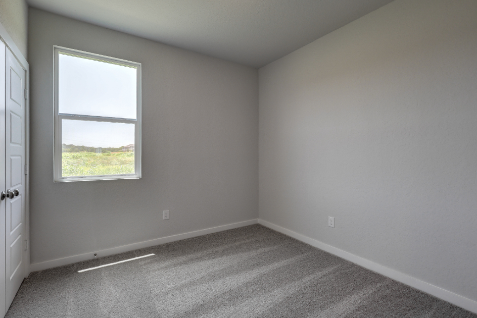 A room with a window and a carpet.