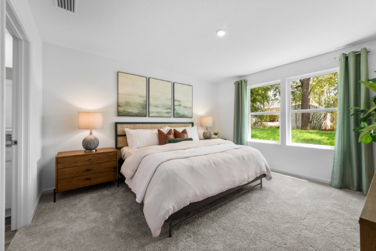 A bedroom with a large window.