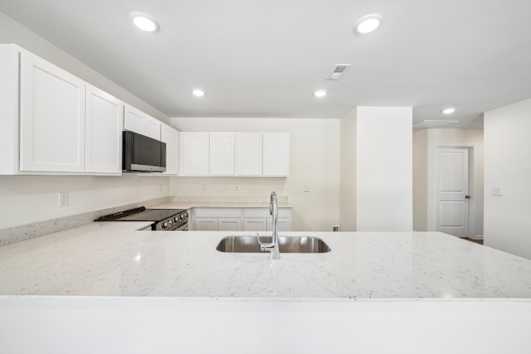 A kitchen with white cabinets.