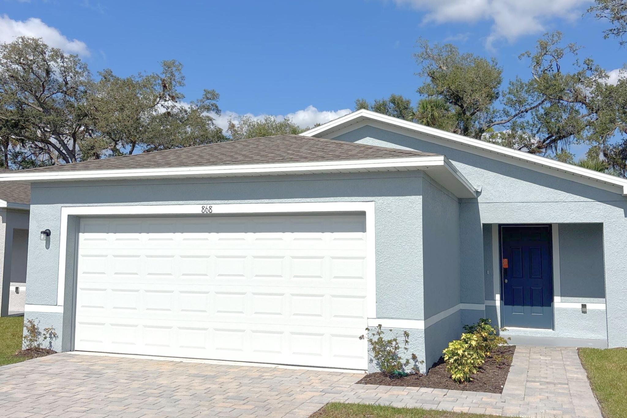 A white garage with a blue door.