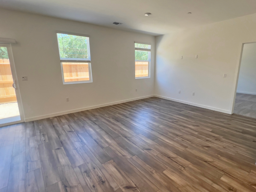 A room with a wood floor and windows.